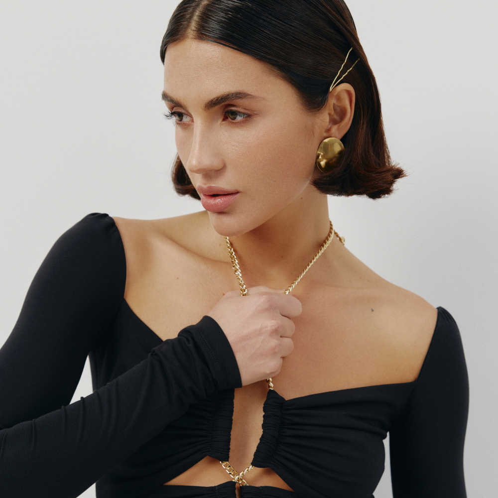 Perfectly fitted knit dress with a gold chain detail and elegant leg-length train. Shop now at our exclusive clothing website.