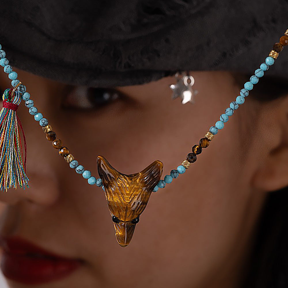Discover the Wild Spirit Wolf Multi-Stone Necklace at The Luxe Maison, featuring a hand-carved tiger's eye or rose quartz wolf pendant, natural gemstone beads, golden accents, and a colorful tassel for a bold, bohemian look.