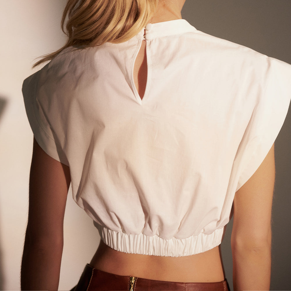 Boxer-style cropped top with asymmetrical front cutouts and elastic waistband.